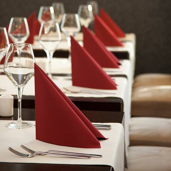 Crimson satin band napkin and cloth napkins on a fine-dining hotel place setting